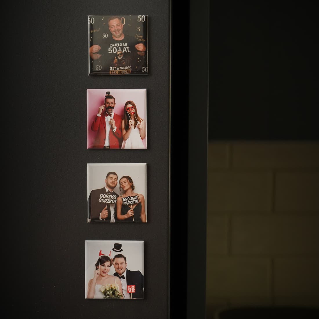Cztery foto-magnesy przypięte do ciemnej ściany